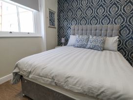A bedroom with a bed and window at Apartment 2 in Weymouth
