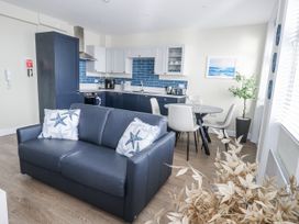 A living room with a sofa and dining area at Vista Mare 2 Weymouth
