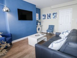 A living room with a television on the wall at Vista Mare 2 in Weymouth