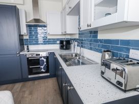 A kitchen with cabinets and appliances at Vista Mare 2 in Weymouth
