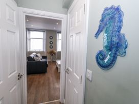 A hallway view with a seahorse decoration and a living room in sight at Vista Mare 2 Weymouth