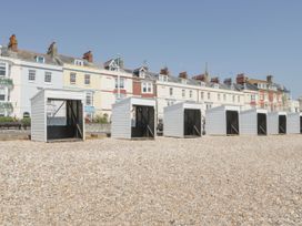 A row of beach huts along the shore at Apartment 3 Weymouth