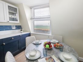 A kitchen with a dining table and chairs at Apartment 3 in Weymouth