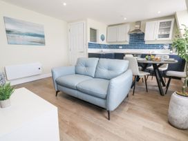 A living room with a sofa and dining area at Apartment 3 in Weymouth