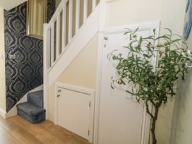 A hallway with a staircase and a plant at Apartment 3 Weymouth