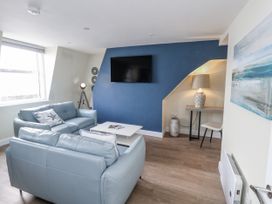 A living room with a television and seating at Vista Mare 3 Weymouth