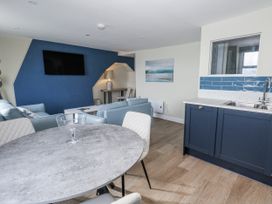 A living room with a sofa and dining table at Vista Mare 3 Weymouth