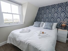 A bedroom with a bed, pillows, and a bedside table at Vista Mare 3 in Weymouth