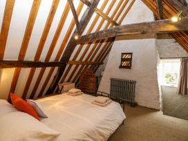 A bedroom with a bed and wooden beams on the ceiling at Thatch Cottage in Trunch