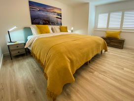 A bedroom with a bed and bedside tables at Sandwood Studios Crantock