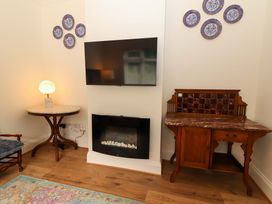 A living room with a television and decorative plates at Rosemont in Adare