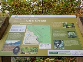 An informational signboard with map and trail details at Glen Creran outdoors with trees in background at Elleric Pods - The Last Resort Fasnacloich near Appin
