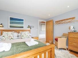 A bedroom with a wooden bed and wardrobe at Smugglers Bodmin Moor, St Breward near St Tudy