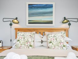 A bedroom with bed and paintings at Smugglers in Bodmin Moor, St Breward near St Tudy
