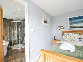 A bedroom with a bed and ensuite bathroom featuring a shower at Smugglers in Bodmin Moor, St Breward near St Tudy