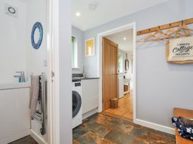 A laundry room with a washing machine and counter at Smugglers Bodmin Moor, St Breward near St Tudy
