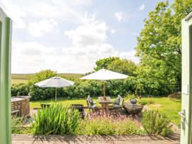 Outdoor seating area with sun umbrellas and flowers at Smugglers Bodmin Moor, St Breward near St Tudy