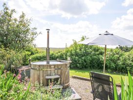 A hot tub with a surrounding garden area at Smugglers Bodmin Moor St Breward near St Tudy
