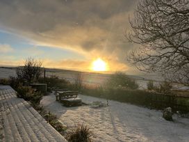 A snowy landscape with a bench and trees at Smugglers Bodmin Moor, St Breward near St Tudy