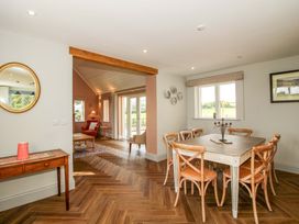 A dining room with a wooden table and chairs at Hoddell Pitch Cottage Kinnerton near New Radnor