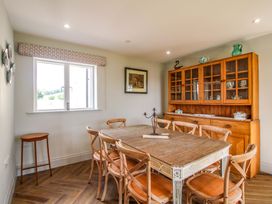 A dining room with a wooden table and chairs at Hoddell Pitch Cottage Kinnerton near New Radnor