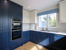 A kitchen with blue cabinets and a sink at Hoddell Pitch Cottage Kinnerton near New Radnor