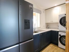 A kitchen with a refrigerator and washing machine at Hoddell Pitch Cottage Kinnerton near New Radnor