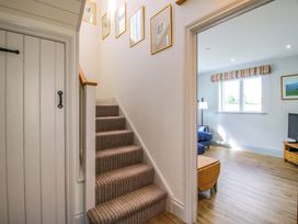A staircase leading to a living area with a lamp and sofa at Hoddell Pitch Cottage Kinnerton near New Radnor