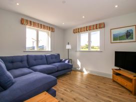 A living room with a blue sofa and television at Hoddell Pitch Cottage Kinnerton near New Radnor