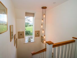 A staircase with light fixtures and framed pictures at Hoddell Pitch Cottage in Kinnerton near New Radnor