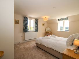 A bedroom with a bed and windows at Hoddell Pitch Cottage Kinnerton near New Radnor