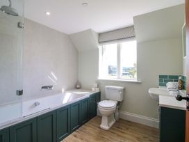 A bathroom with a bathtub, toilet, and sink at Hoddell Pitch Cottage in Kinnerton near New Radnor