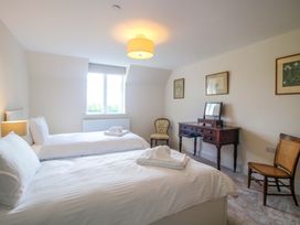 A bedroom with two beds and a dresser with a mirror at Hoddell Pitch Cottage Kinnerton near New Radnor