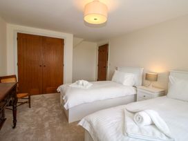 A bedroom with two beds and a table at Hoddell Pitch Cottage in Kinnerton near New Radnor