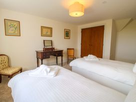 A bedroom with two beds and a table at Hoddell Pitch Cottage Kinnerton near New Radnor