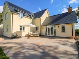 A house with a patio and umbrellas at Hoddell Pitch Cottage Kinnerton near New Radnor