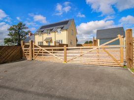 A house with a wooden gate and gravel driveway at Hoddell Pitch Cottage in Kinnerton near New Radnor