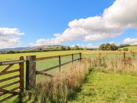 A fenced field with a gate and trees at Hoddell Pitch Cottage Kinnerton near New Radnor