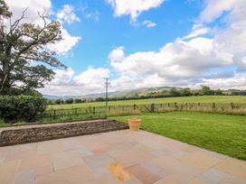 A patio with grass and a view of mountains at Hoddell Pitch Cottage in Kinnerton near New Radnor
