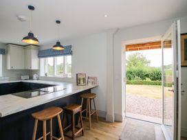 A kitchen with a marble countertop and bar stools at Hoddell Pitch Cottage Kinnerton near New Radnor