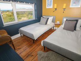A bedroom with two single beds a window and wooden floor at Min-Y-Ffordd in Dinas Cross