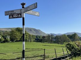 A signpost with directions in a field at Winn's Cottage in Pooley Bridge
