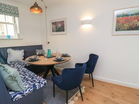 A dining room with a round table and seating at Weyside in Weymouth