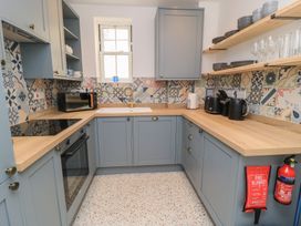 A kitchen with cabinets, shelves, and appliances at Weyside in Weymouth