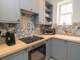 A kitchen with appliances and tiles at Weyside in Weymouth