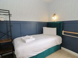 A bedroom with a bed and shelf at Weyside in Weymouth