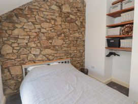 A bedroom with a stone wall and a bed at 41 St. James Street in Narberth