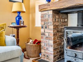 A living room with an armchair and a fireplace at Bodior Lodge in Rhoscolyn