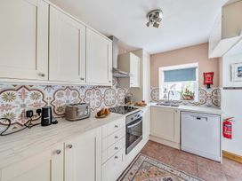 A kitchen with cabinets, oven, sink, and countertop at Bodior Lodge in Rhoscolyn