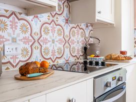 A kitchen with a stove, countertop, and fruit at Bodior Lodge in Rhoscolyn